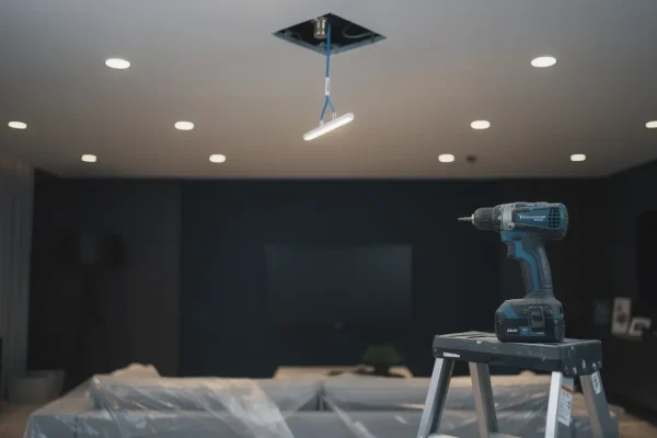 Recessed pot lights being installed in a living room ceiling